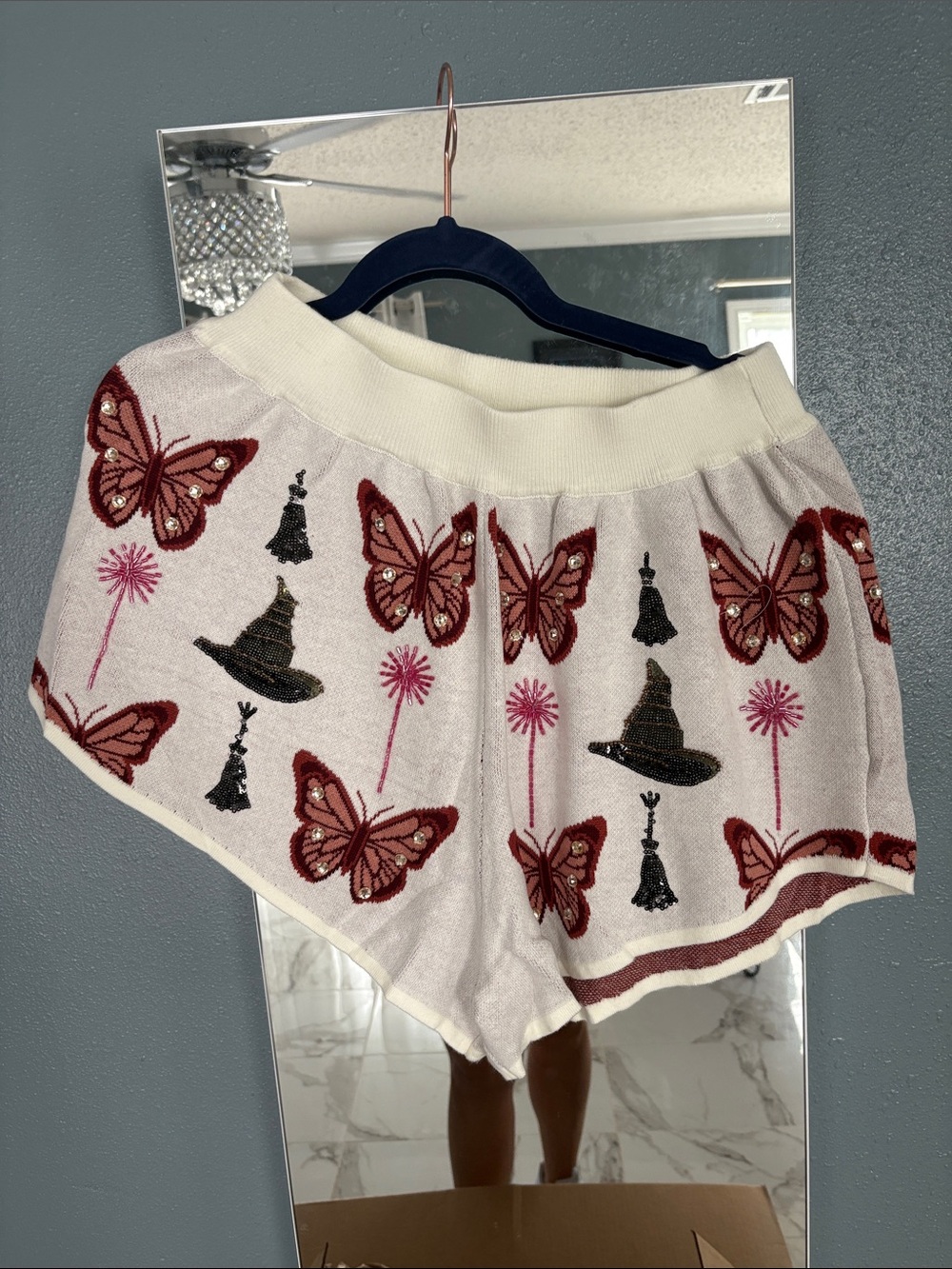 QUEEN OF SPARKLES Cream Shorts with Red Butterfly & Black Hat Motifs